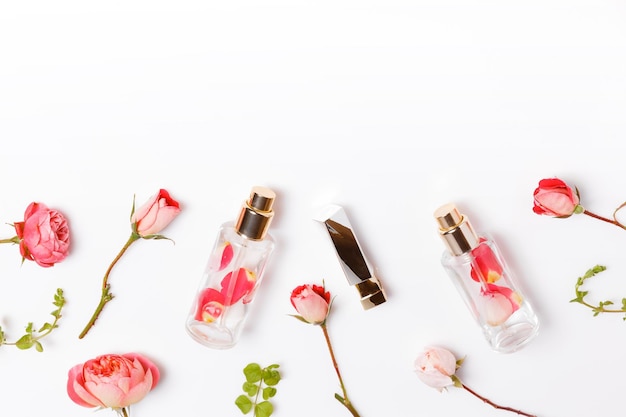 Óleo de aroma essencial com rosas no espaço de trabalho de beleza de fundo de madeira com vista superior de cosméticos de rosas f