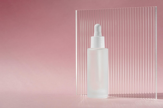 Óleo de soro com colágeno e peptídeo em frasco transparente branco com conta-gotas no cenário de decoração rosa com folha acrílica com nervuras Tratamento de cuidados com a pele maquete de cuidados com a pele embalagem produto cosmético líquidoxA