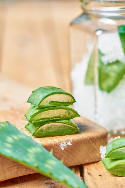 Óleo essencial de aloe vera e gel de aloevera com folha verde de cacto no fundo da mesa de madeira.