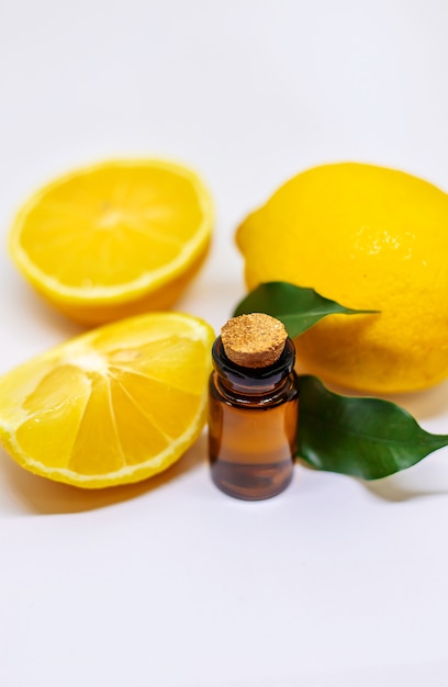 Óleo essencial de limão em uma garrafa e limões