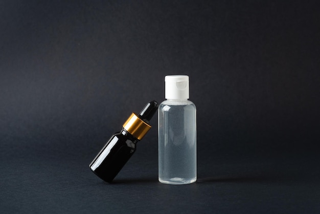 Óleo facial e garrafa de tônico de água micelar em fundo preto
