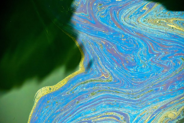 Óleo se espalhando na superfície do mar Vista aérea de cima para baixo como uma pintura abstrata com o padrão de derramamento de óleo colorido do arco-íris