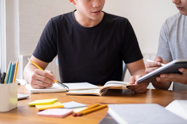 Lern-, bildungs- und schulkonzept. junge frau und mann, die für einen test oder eine prüfung studieren. lehrbücher mit freunden. der campus für junge studenten hilft freunden beim aufholen und lernen.