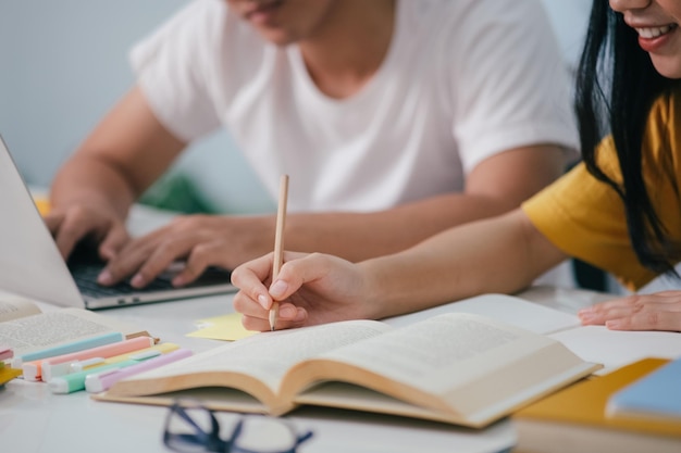 Lernbildung und Schulkonzept Junge Frau und Mann, die für einen Test oder eine Prüfung studieren Tutor Bücher mit Freunden Der Campus junger Studenten hilft Freunden, aufzuholen und zu lernen