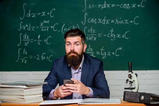 Lernen Sie Technologie Moderne Kommunikation Nachricht senden Schulanwendung Studieren Sie Technologie Schullehrer halten Handy-Tafelhintergrund Lehrerbärtiger Mann lernt, moderne Technologie zu nutzen