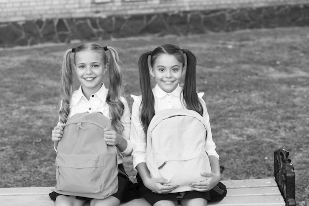 Foto lernen sie zusammen, um mehr zu erreichen glückliche mädchen lernen in der grundschule kleine kinder halten taschen im freien heimstudium bildung und schule privatunterricht zurück zur schule dem lernen verschrieben