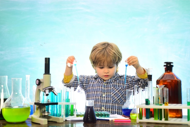 Lernen zu Hause Biologieexperimente mit Mikroskop Bereit für die Schule Chemie Bildung Kind im Klassenzimmer mit Tafel im Hintergrund