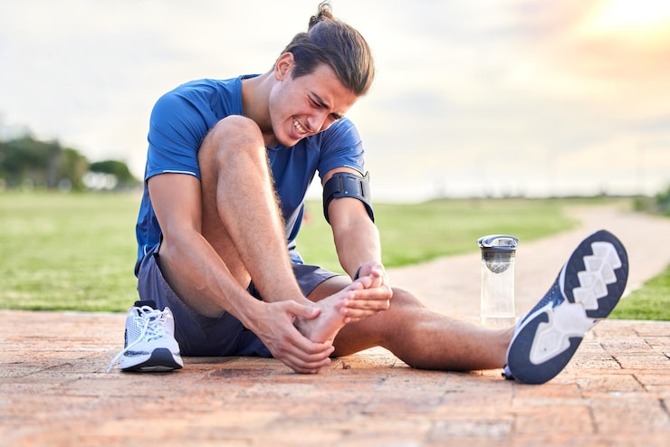 Foto lesão de aptidão e dor no pé com homem no parque para inflamação de espasmo muscular e problema nas articulações treino de corrida e exercício com atleta e emergência esportiva para sofrimento de saúde e tornozelo quebrado