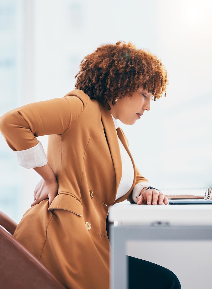 Foto lesão de dor nas costas e mulher negra no escritório na mesa com problema de coluna, dor nas costas e tensão muscular emergência médica de estresse e corpo de massagem de trabalhadora para acidente, tensão e pressão nas articulações