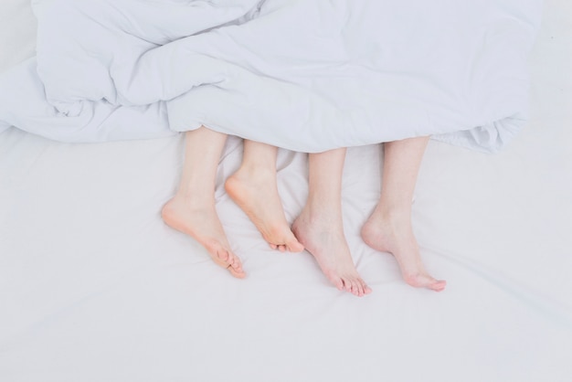 Lesben Paar Füße aus der Decke über dem Bett