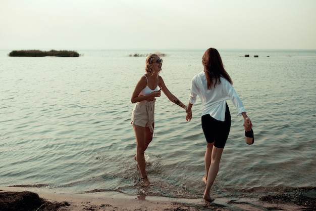 Lesbenpaar viel Spaß am Strand Schöne Freundinnen entspannen sich gerne in der Nähe des Meeres