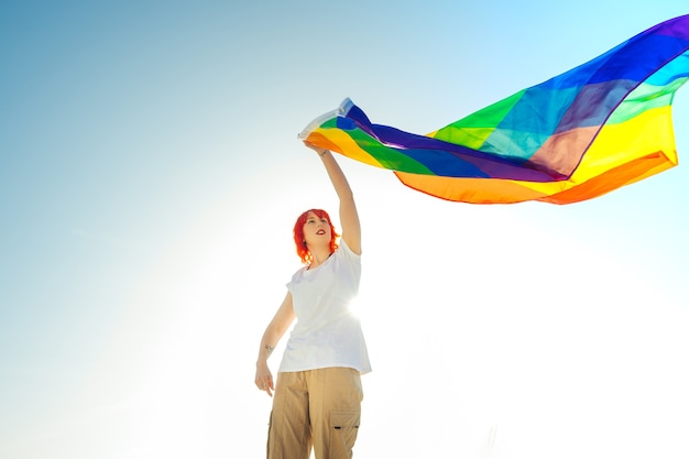 Lesbische Frau mit Regenbogenflagge. LGBT-Konzept
