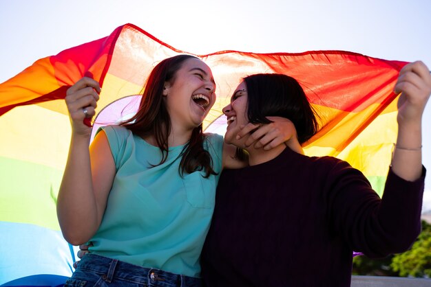 lesbische Mädchen, die Spaß daran haben, sich selbst zu malen und mit der LGtb-Flagge am Stolztag LGtb-Konzept