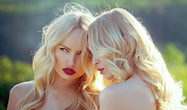 Lesbische Mädchen mit sexy roten Lippen Schwestern Zwillinge im Sommer sonniges Wetter Frauen mit blonden Haaren und ma