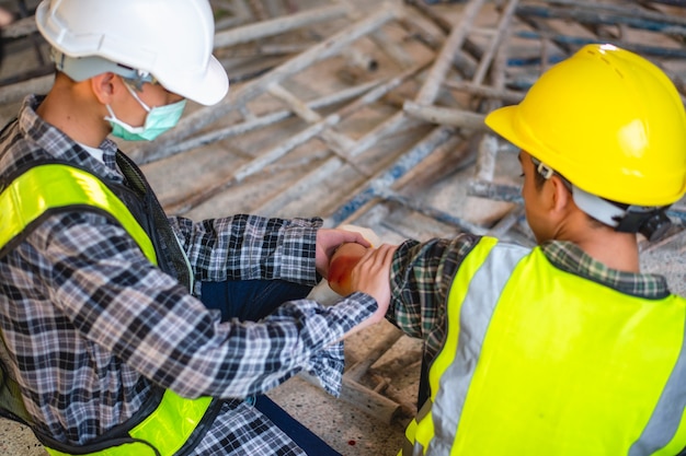 Lesión física en el trabajo del trabajador de la construcción. Lesión sangrando por accidente de trabajo en una pila de acero de andamio cayendo para chocar con el brazo.