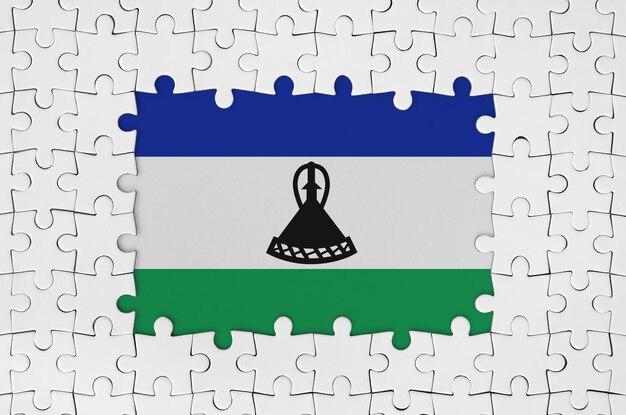 Lesotho-Flagge im Rahmen aus weißen Puzzleteilen mit fehlendem Mittelteil