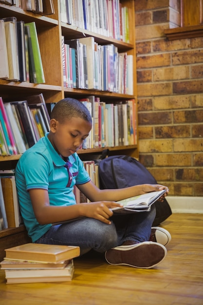 Lesung des kleinen Jungen auf Bibliotheksboden