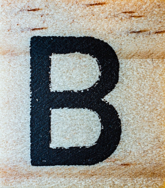 Letra B gravada a laser em macro de madeira balsa detalhe de textura fechada