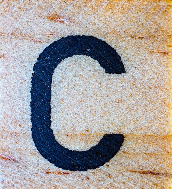 Letra C gravada a laser em macro de madeira balsa detalhe de textura fechada