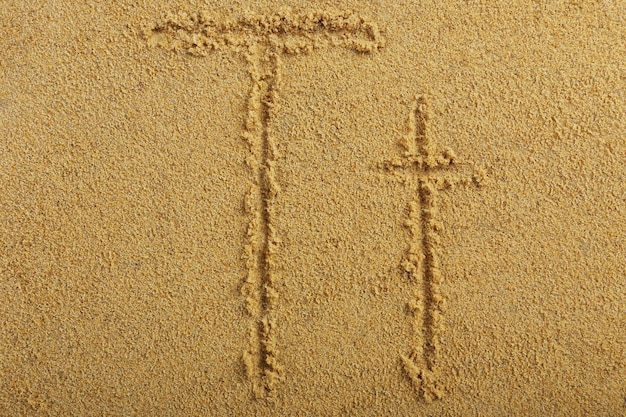 Letra do alfabeto escrita na areia molhada da praia