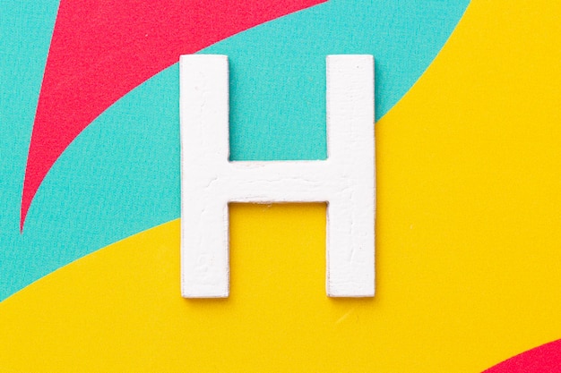 Foto letra h del alfabeto en la vista superior de fondo de color