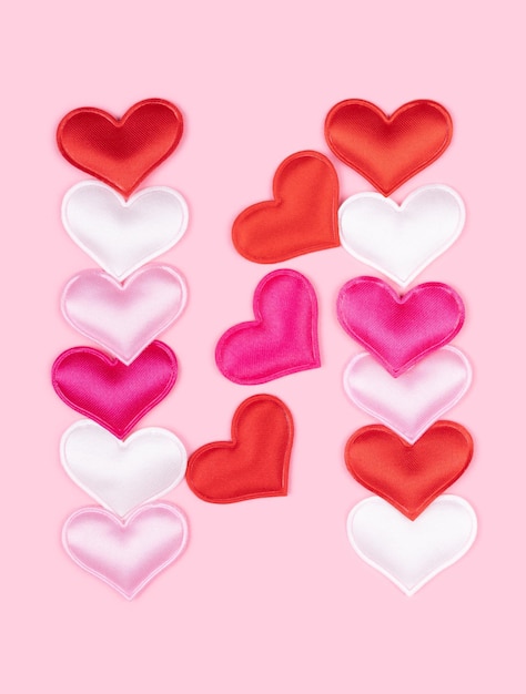 Letra N hecha de corazones de atlas brillantes aislados en un fondo rosa sólido fuente de corazones del alfabeto del amor