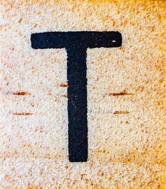 Letra T gravada a laser em macro de madeira balsa detalhe de textura fechada