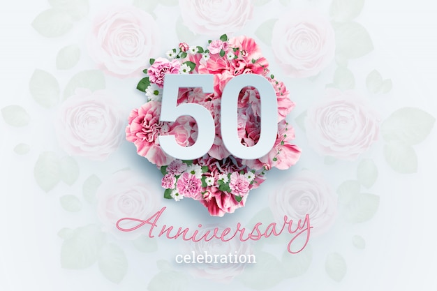 Foto letras 50 números y texto de celebración de aniversario en flores rosadas.