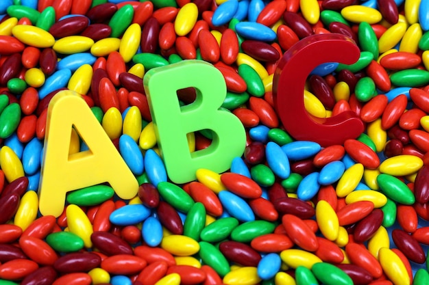 Las letras ABC de colores se colocan en caramelos de colores. Inglés para principiantes.