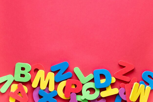 Letras del alfabeto en diferentes colores sobre un fondo rojo. Alphabet Study, ABC, Education Concept