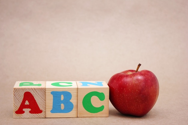 Letras del alfabeto inglés ABC junto a la manzana roja. Aprendizaje de lengua extranjera.