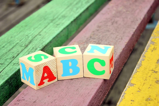 Letras del alfabeto inglés en bloques de juguete de madera que se encuentran en las tablas antiguas