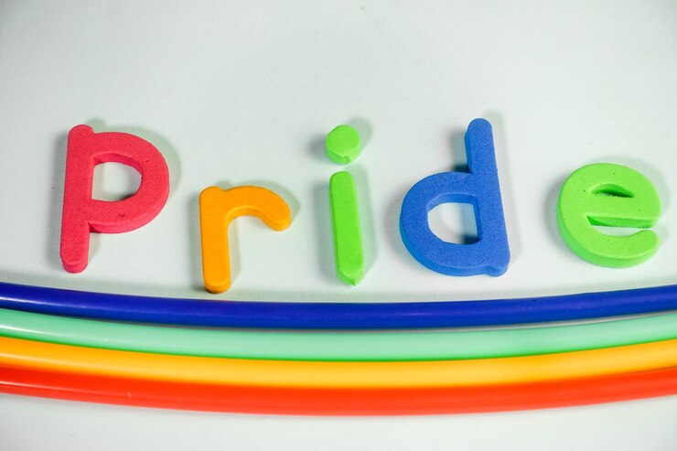 Foto letras del arco iris deletreando orgullo sobre un fondo blanco.