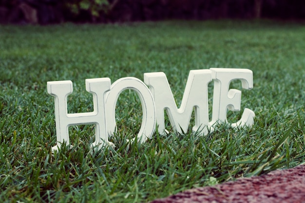 Letras blancas en casa en el patio de césped verde césped