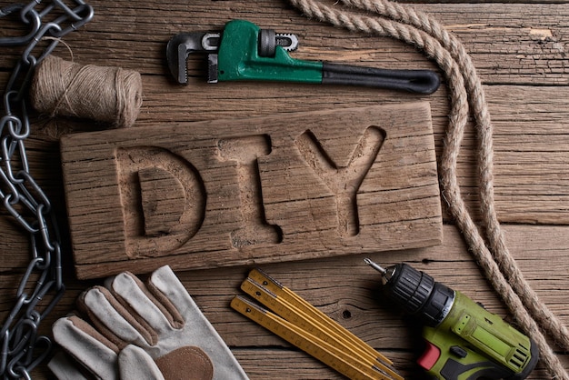 Letras de bricolaje en una tabla de madera en el fondo de las herramientas de trabajo. Hágalo usted mismo concepto.