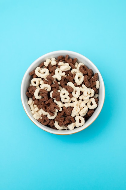 Letras de cereales simples y de chocolate en tazón de naranja.