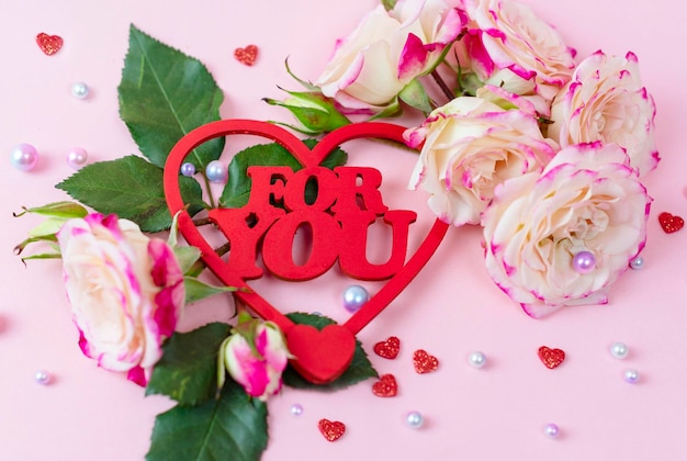 Letras coloridas de madeira para você e delicado buquê de rosas peônia espessas com pérolas no conceito de fundo rosa de comemorar o dia dos namorados