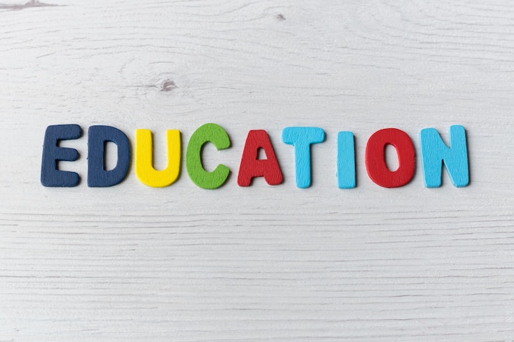 Foto letras coloridas con la palabra educación en un fondo de madera clara