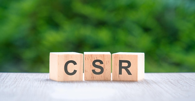 Letras CSR en cubo de bloque de madera con fondo de naturaleza verde