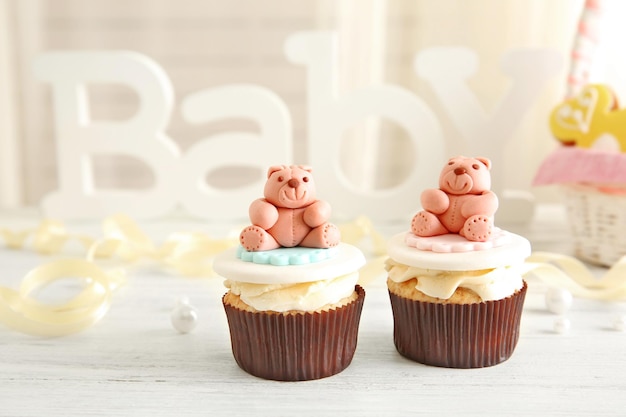 Letras da palavra bebê e cupcakes na mesa