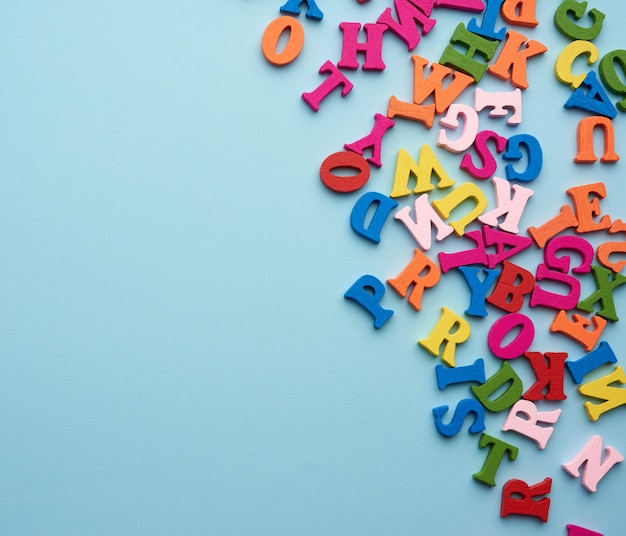 Letras de madeira coloridas do alfabeto inglês sobre um fundo azul