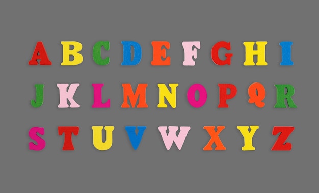 letras de madeira do alfabeto inglês multicoloridas sobre um fundo cinzento