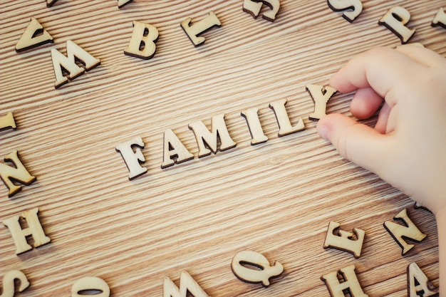 Letras de madeira, palavras. foco seletivo. mãos de criança.