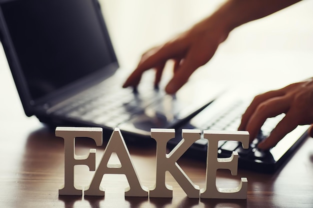 Las letras deletrearon la palabra fake El concepto de tecnología de la información moderna Fake y hechos en las noticias