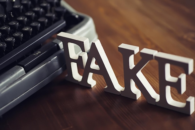 Las letras deletrearon la palabra fake El concepto de tecnología de la información moderna Fake y hechos en las noticias