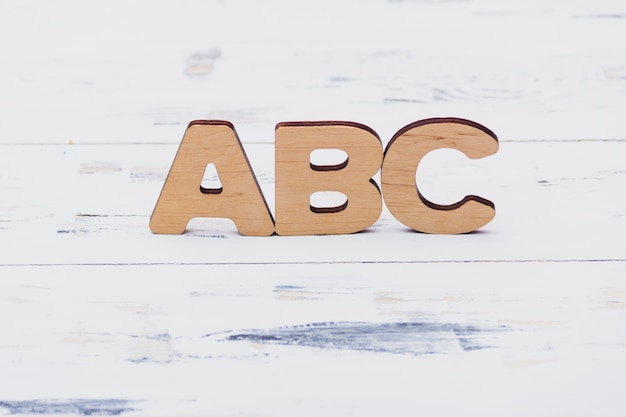 Letras do ABC em fundo branco de madeira. Conceito de educação. Espaço de cópia livre.