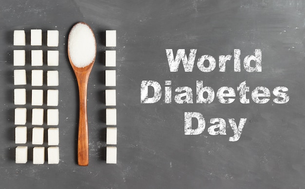 Letras do Dia Mundial da Diabetes em giz em um fundo cinza com torrões de açúcar