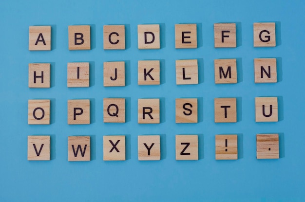 Letras de madera alfabeto inglés sobre un fondo azul.