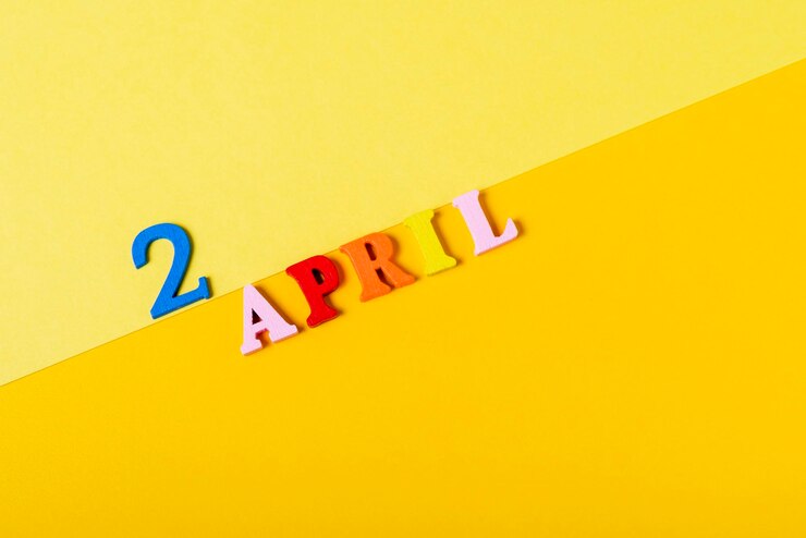 Foto letras de madera el dos de abril sobre un fondo amarillo