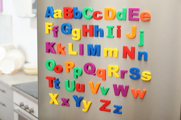 Foto letras magnéticas coloridas en la puerta del refrigerador en el interior